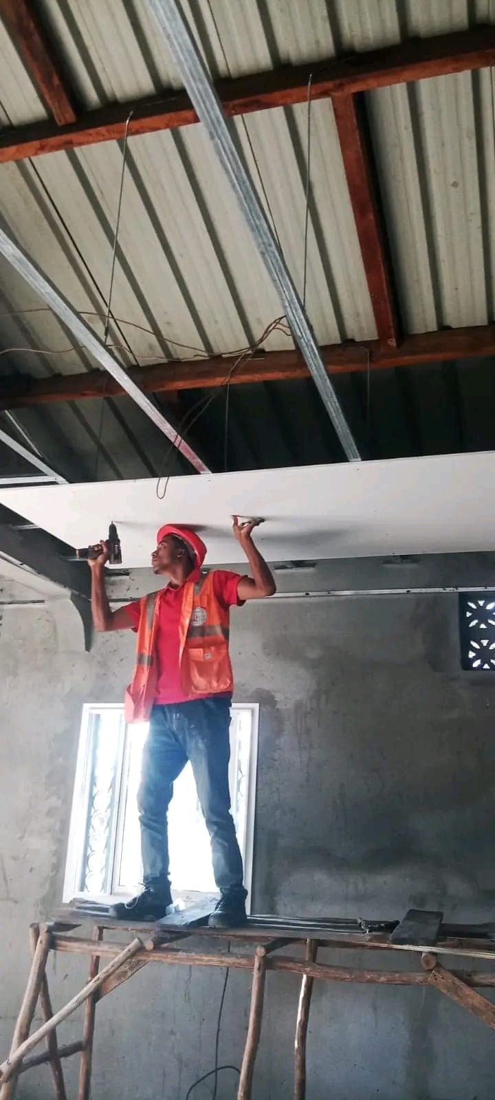 Pose de plaques de faux-plafond sur chantier